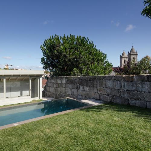 a backyard with a retaining wall and a swimming pool at L'Olivier 23 - 2 apartments in a recently renovated Guesthouse in Porto