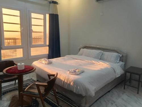 Schlafzimmer mit einem Bett, einem Tisch und Stühlen in der Unterkunft Jabal Shams bayt kawakib in Misfāh