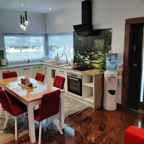 a kitchen with a table and a sink and a stove at Roztocze 3 kroki od sosny in Zamość