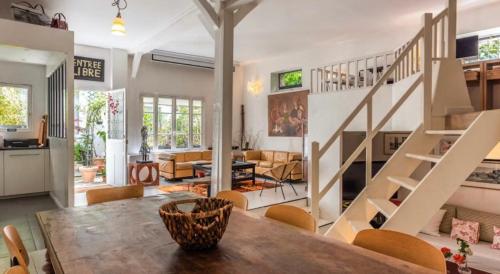 - un salon avec une table et un escalier dans l'établissement Maison Antoinette Paris - MaisonNomadeChic, à Paris