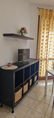 escritorio con TV en la parte superior de la habitación en Bilocale via Rimini 5C, en Pomezia