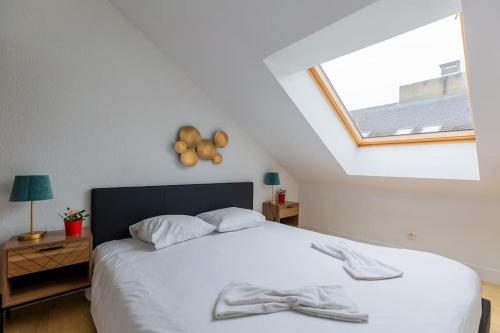 a bedroom with a white bed with a window at Le petit Marcel - T3 / 6P - 60 m2 - hyper Centre ville Metz in Metz