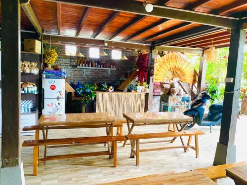 a patio with two wooden tables and a refrigerator at Homestay Chinh Bi in Yên Bái