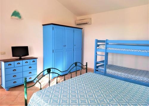 a bedroom with two bunk beds and a tv at Agriturismo Sa Ruda in Càbras