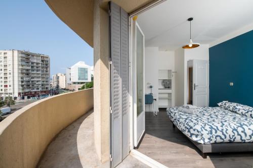 une chambre avec un lit et un balcon dans l'établissement #Rubis du Sud - Wifi - Clim -Parking - Balcon#, à Toulon