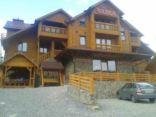 a large wooden building with a car parked in front of it at Готель Чарда in Bukovel