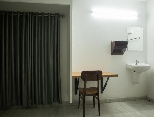 a bathroom with a desk and a sink and a toilet at Urban Oasis Homestay: AC Bedrooms in Trichūr
