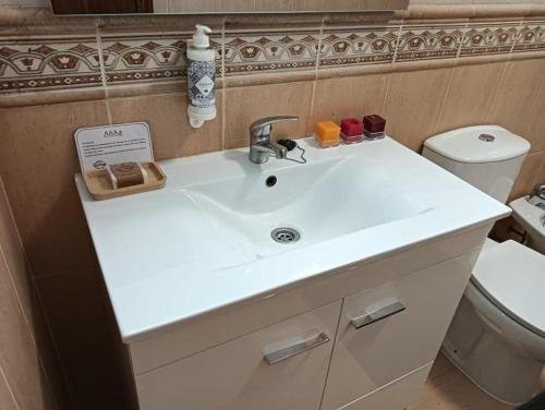 a bathroom with a white sink and a toilet at Alojamentos Vila Alpalhão in Alpalhão
