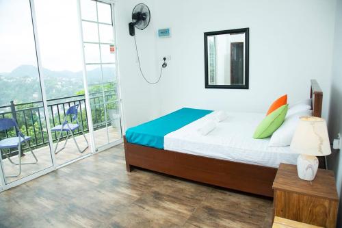 a bedroom with a bed and a balcony at Eden Rock Luxurious Accommodation in Kandy