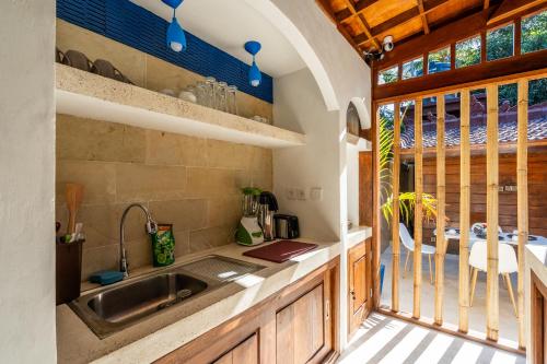 une cuisine avec un évier, une fenêtre et une table dans l'établissement Paradise Luxury Villa, à Gili Air