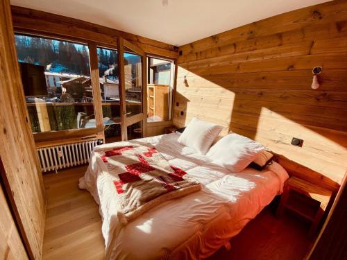 a bedroom with a bed in a room with wooden walls at Appartement La Clusaz, 3 pièces, 6 personnes - FR-1-459-203 in La Clusaz