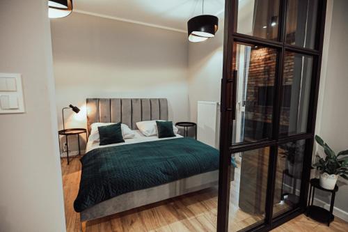 - une chambre avec un lit et une couverture verte dans l'établissement LOFT Luxury Apartment & Parking, à Leszno