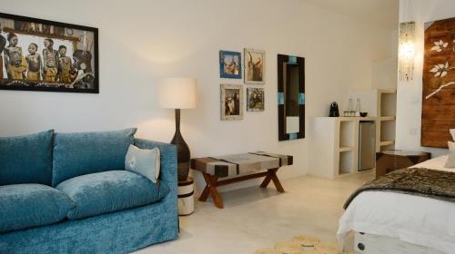 a living room with a blue couch and a bed at Latitude 15 Degrees in Lusaka