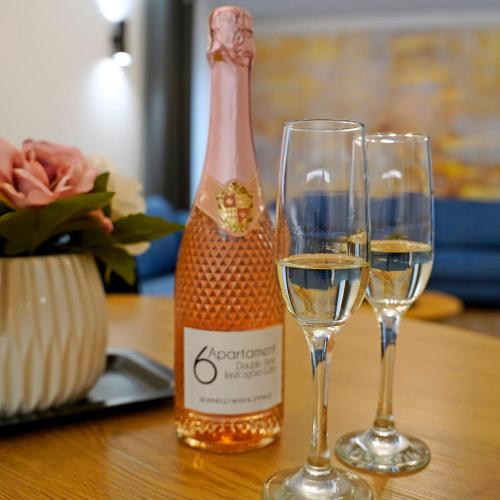 two glasses of white wine next to a bottle of champagne at Apartament 6 Double Rest Jastrzębia Góra in Jastrzębia Góra