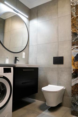 a bathroom with a toilet and a sink and a mirror at Apartament 6 Double Rest Jastrzębia Góra in Jastrzębia Góra