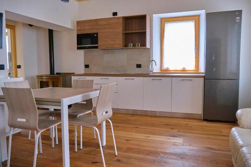 a kitchen with a table and chairs in a room at Bilocale vista lago in Auronzo di Cadore