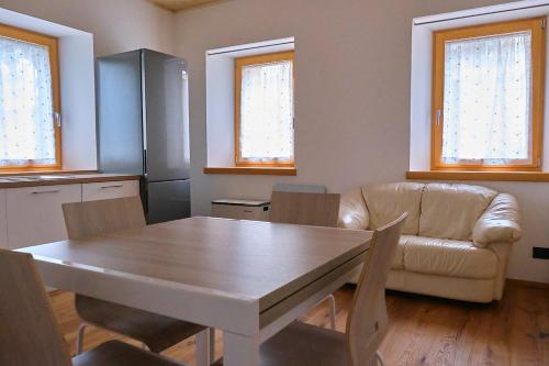 a living room with a table and a couch at Bilocale vista lago in Auronzo di Cadore