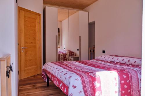 a bedroom with a bed and a wooden floor at Bilocale vista lago in Auronzo di Cadore
