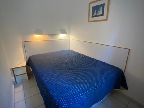 - une chambre avec un lit bleu dans l'établissement Appartement 2 pièces avec terrasse et vue mer, accès piscine et parking inclus - FR-1-504-677, à Saint-Raphaël