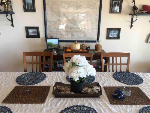 a dining room with a table with a vase of flowers at The Huron Hutch in Evergreen Shores