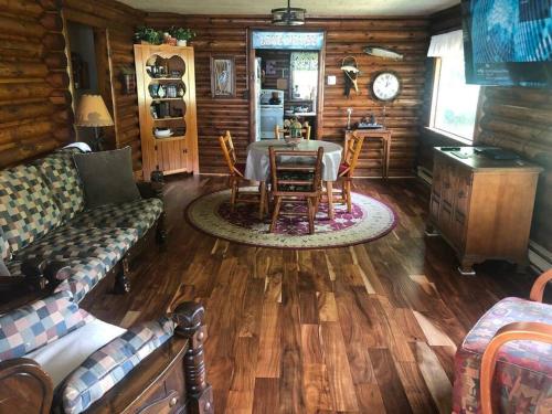 a living room with a table in a log cabin at The Huron Hutch in Evergreen Shores