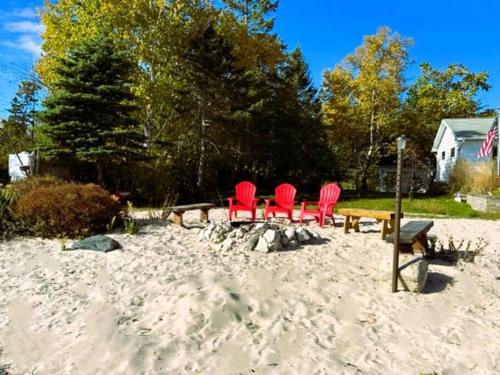 a group of chairs and a picnic table in the sand at The Huron Hutch in Evergreen Shores