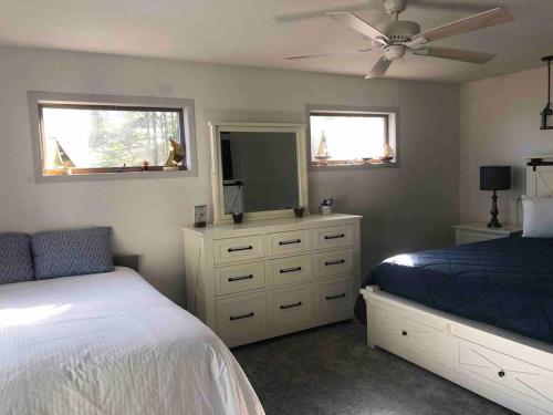 a bedroom with a bed and a dresser with a mirror at The Huron Hutch in Evergreen Shores
