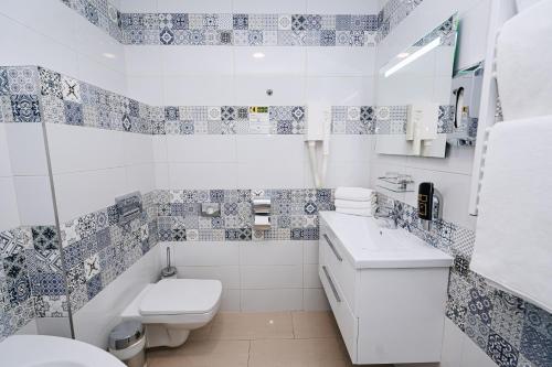 a white bathroom with a toilet and a sink at Union Hotel Prague in Prague