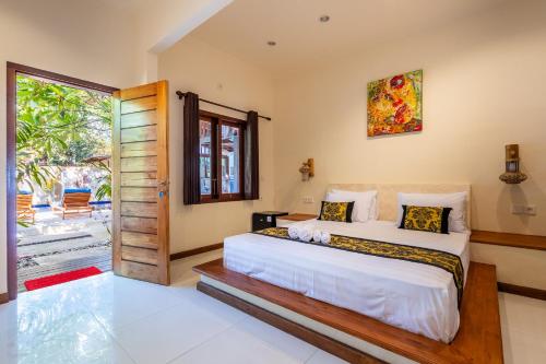 a bedroom with two beds and a sliding glass door at Paradise Luxury Villa in Gili Air