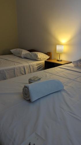 2 Betten in einem Hotelzimmer mit einem Handtuch auf dem Bett in der Unterkunft Hospedaje Latinos in Tarapoto