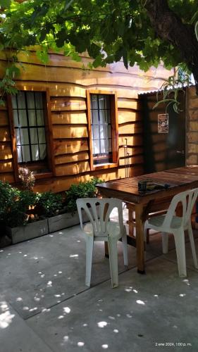 una mesa de madera y sillas frente a una cabaña en El Nogal Viedma en Viedma