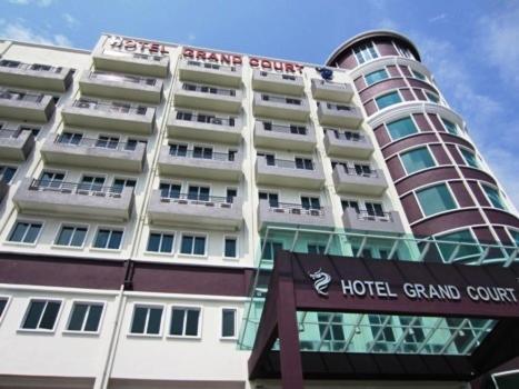 a hotel building with a sign in front of it at Grand Court Hotel in Teluk Intan