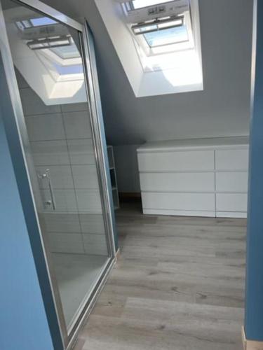 La salle de bains est pourvue d'un miroir et d'une lucarne. dans l'établissement Maison en Baie du Mont St Michel, à Le Val-Saint-Père