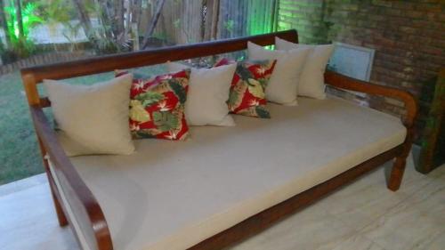 a wooden bench with many pillows on it at Itacimirim Villas da Praia in Camacari