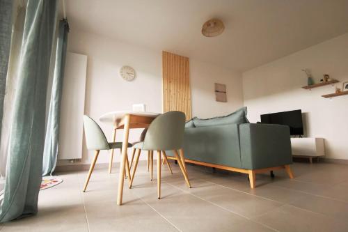 un salon avec une table, des chaises et un canapé dans l'établissement Cocoon with terrace at 2 steps from the sea, à La Baule