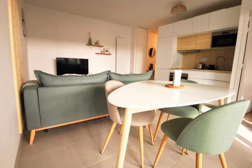 un salon avec une table et un canapé dans l'établissement Cocoon with terrace at 2 steps from the sea, à La Baule