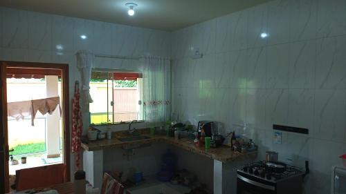 kuchnia z blatem, umywalką i oknem w obiekcie Casa da Serra w mieście Pouso Alto