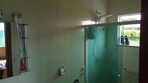 W łazience znajduje się prysznic ze szklanymi drzwiami. w obiekcie Casa da Serra w mieście Pouso Alto