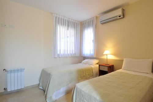 Habitación de hotel con 2 camas y ventana en AVIS Departamentos peatonal en Villa Carlos Paz