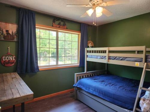 a bedroom with two bunk beds and a ceiling fan at Riverfront~On ATV Trials~Near Mackinac Island in Hessel