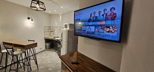 TV de pantalla plana colgada en la pared de la cocina en Cheval Blanc en Villa Gesell
