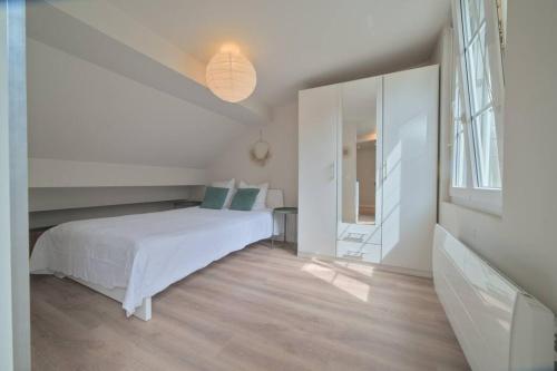 ein weißes Schlafzimmer mit einem Bett und einem Spiegel in der Unterkunft Le studio de la république - 2P - Hyper centre Metz in Metz