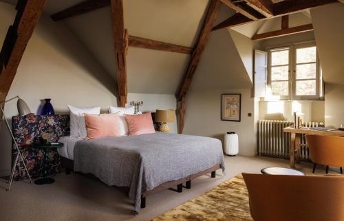 a bedroom with a bed with pink pillows at Domaine de Locguénolé & Spa - Relais & Chateaux in Kervignac