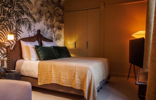 a hotel room with a bed and a tv at Domaine de Locguénolé & Spa - Relais & Chateaux in Kervignac