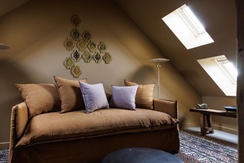 a room with a couch with pillows on it at Domaine de Locguénolé & Spa - Relais & Chateaux in Kervignac