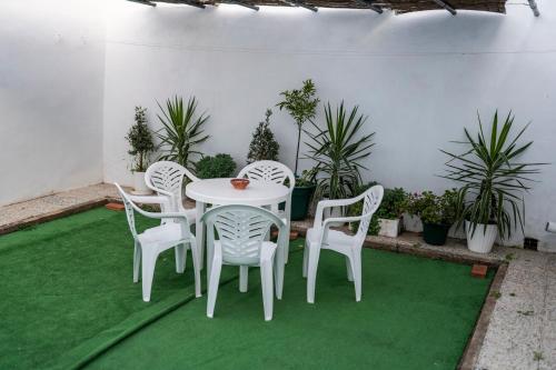 eine Terrasse mit einem Tisch, Stühlen und Pflanzen in der Unterkunft Casa Hacha in Corteconcepción