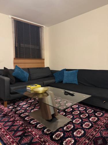a living room with a black couch and a table at Flat 71 in Bristol
