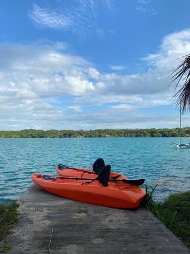 a red kayak sitting on a dock on a lake at Casa Abeii. Lugar mágico frente a la laguna in Xul-Ha