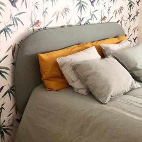 a gray couch with four pillows on top of it at Caparica Beach House in Costa da Caparica