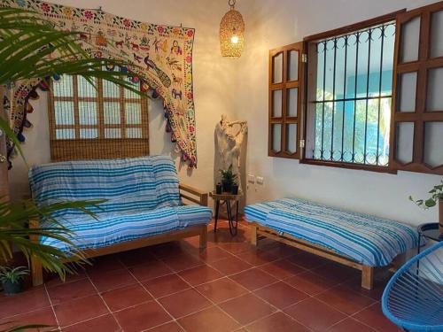 a living room with two benches and windows at Casa Abeii. Lugar mágico frente a la laguna in Xul-Ha